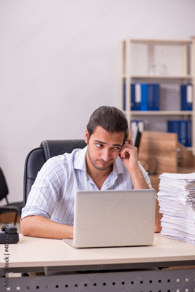 Young male employee unhappy with excessive work Young male employee unhappy with excessive work