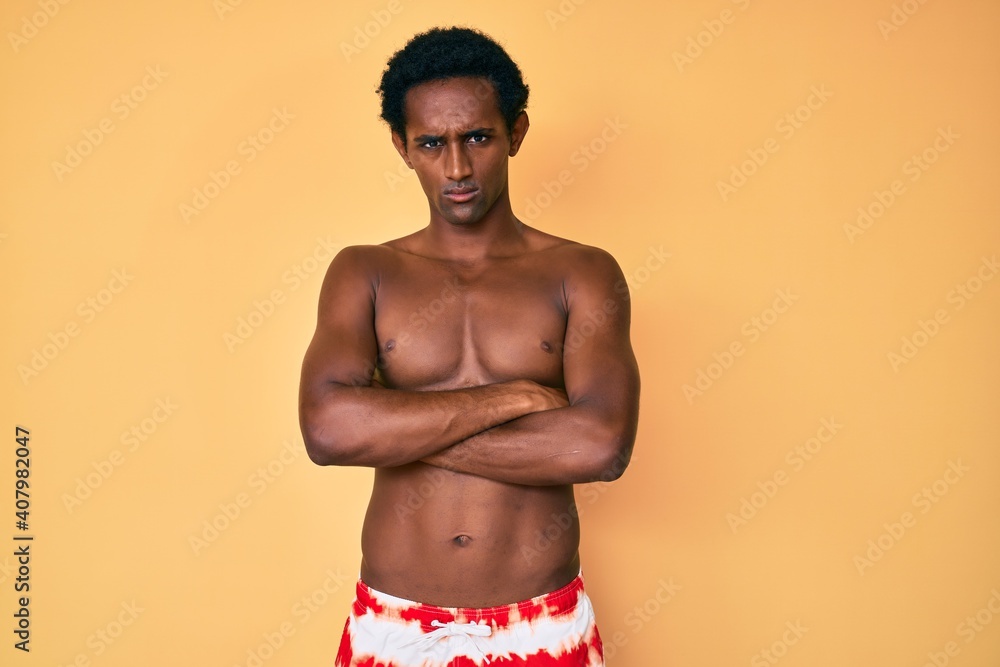 Fototapeta premium African handsome man wearing swimsuit skeptic and nervous, disapproving expression on face with crossed arms. negative person.