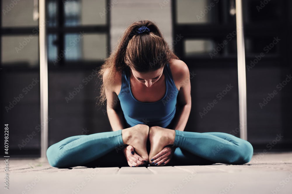 Fototapeta premium Young caucasian woman practicing yoga on the city streets.