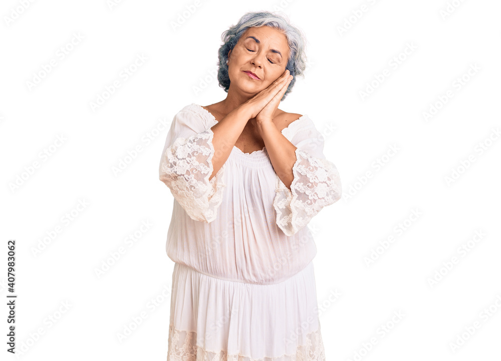 Senior woman with gray hair wearing bohemian style sleeping tired dreaming and posing with hands together while smiling with closed eyes. Senior woman with gray hair wearing bohemian style sleeping tired dreaming and posing with hands together while smiling with closed eyes.