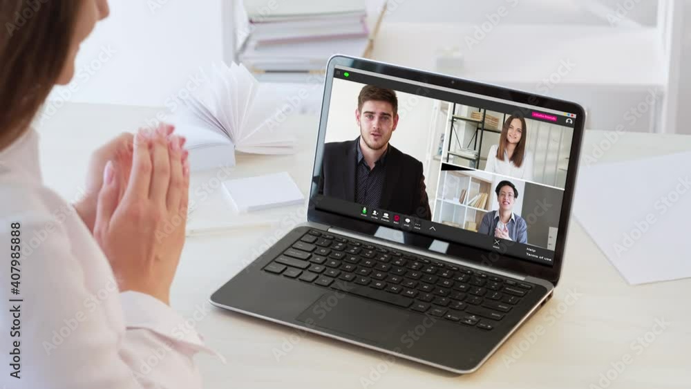 Video call. Online conference. Group chat. Remote work. Diverse multiethnic professional team greeting celebrating successful cooperation applauding on laptop screen at light workplace. Video call. Online conference. Group chat. Remote work. Diverse multiethnic professional team greeting celebrating successful cooperation applauding on laptop screen at light workplace.