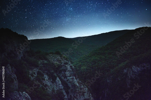 Starry sky over the mountains at night in summer.