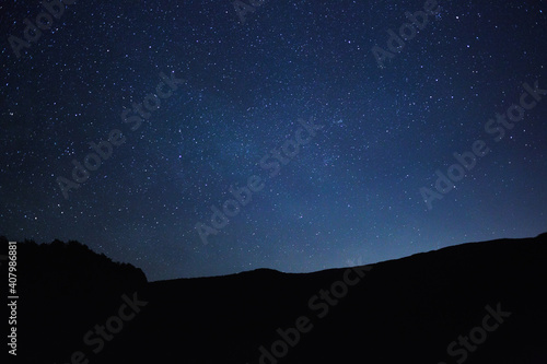 Starry sky over the mountains at night in summer.