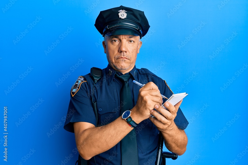 Handsome middle age mature man wearing police uniform writing a ticket relaxed with serious expression on face. simple and natural looking at the camera. Handsome middle age mature man wearing police uniform writing a ticket relaxed with serious expression on face. simple and natural looking at the camera.