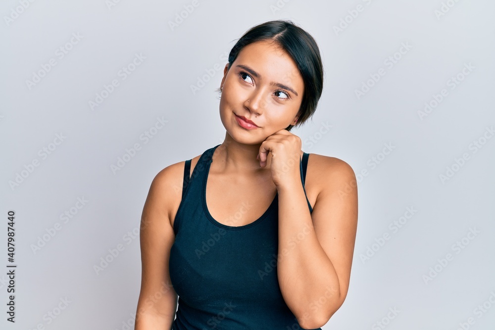 Beautiful young woman with short hair wearing casual clothes thinking concentrated about doubt with finger on chin and looking up wondering Beautiful young woman with short hair wearing casual clothes thinking concentrated about doubt with finger on chin and looking up wondering