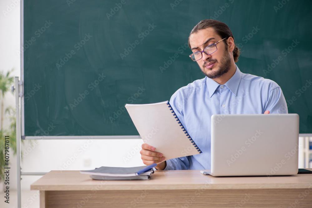 Young male teacher in the classroom in tele-education concept Young male teacher in the classroom in tele-education concept