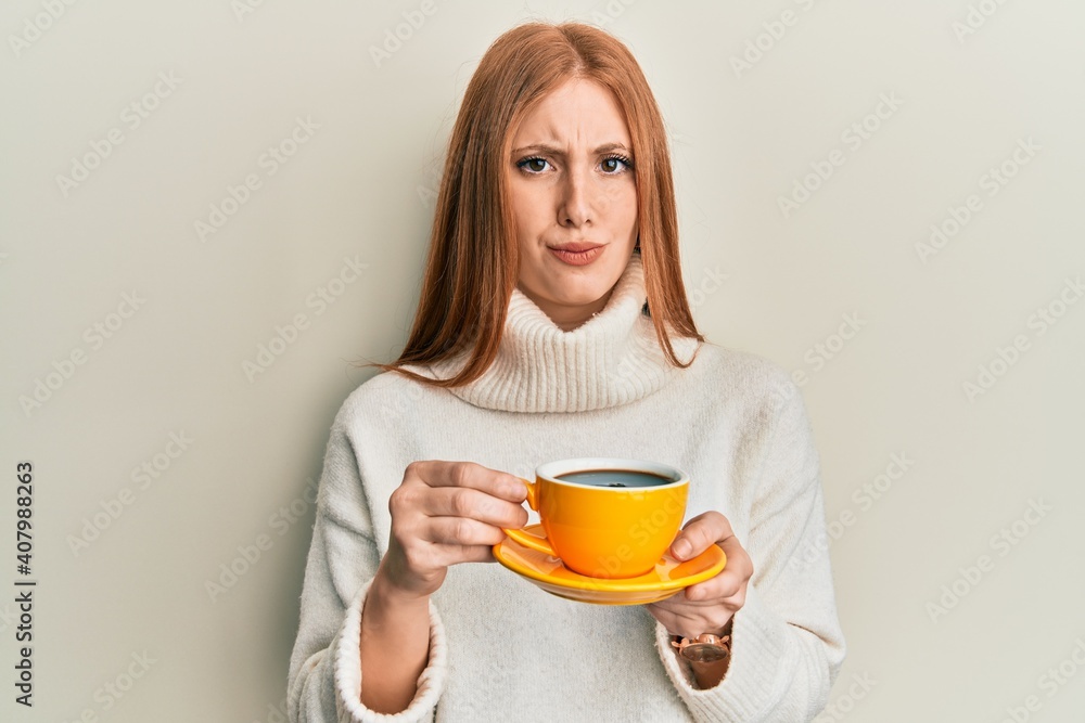 Young irish woman drinking a cup of coffee skeptic and nervous, frowning upset because of problem. negative person.