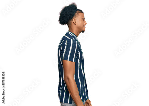 African american man with afro hair wearing casual clothes looking to side, relax profile pose with natural face with confident smile.