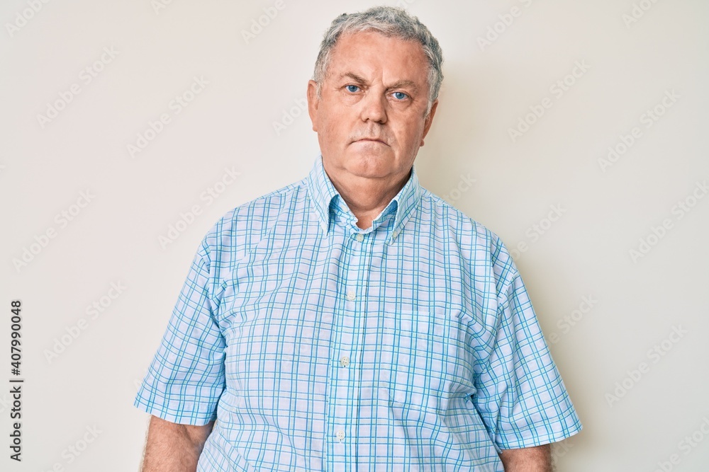 Senior grey-haired man wearing casual clothes with serious expression on face. simple and natural looking at the camera. Senior grey-haired man wearing casual clothes with serious expression on face. simple and natural looking at the camera.