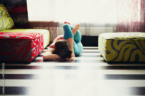 Young woman practicing yoga at home near the wall photo
