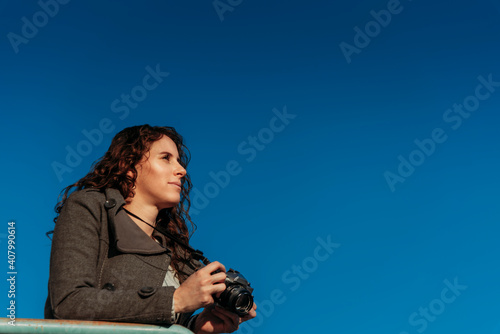 young woman with camera over the sky