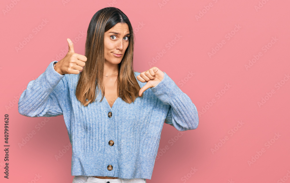 Young woman wearing casual clothes doing thumbs up and down, disagreement and agreement expression. crazy conflict Young woman wearing casual clothes doing thumbs up and down, disagreement and agreement expression. crazy conflict
