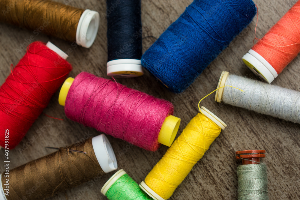 Many different colorful threads on a table in a tailor shop Many different colorful threads on a table in a tailor shop