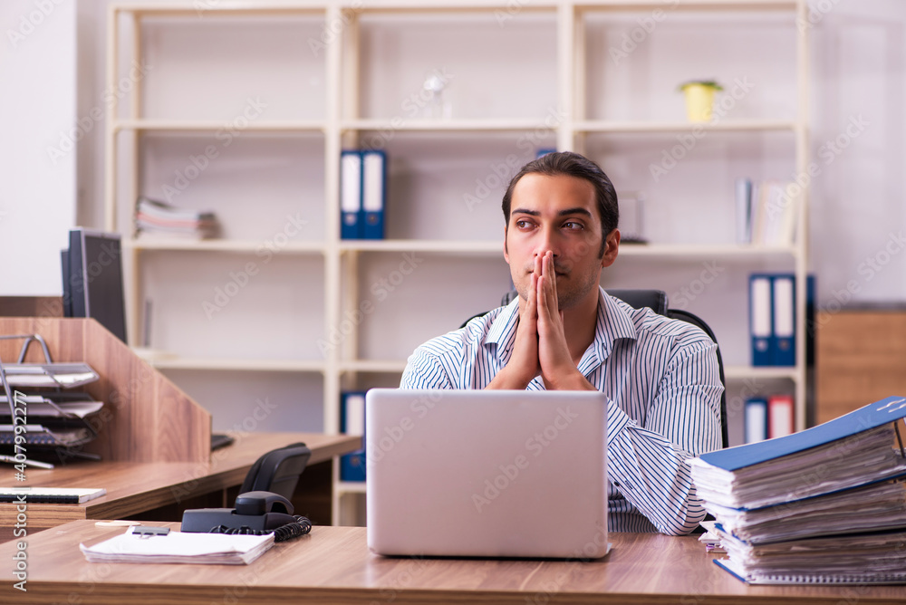 Young male employee working in the office Young male employee working in the office