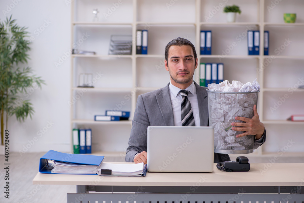 Young businessman rejecting new ideas with lots of papers Young businessman rejecting new ideas with lots of papers