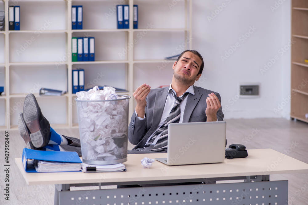 Young businessman rejecting new ideas with lots of papers Young businessman rejecting new ideas with lots of papers