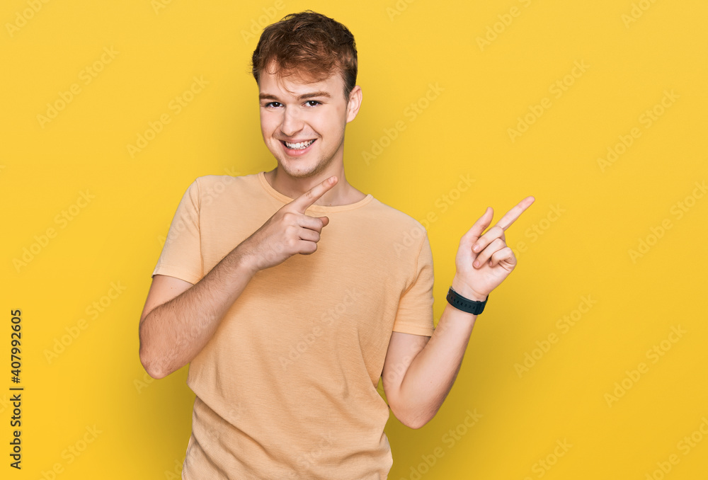 Young caucasian man wearing casual clothes smiling and looking at the camera pointing with two hands and fingers to the side. Young caucasian man wearing casual clothes smiling and looking at the camera pointing with two hands and fingers to the side.