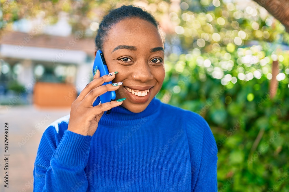 Young african american woman smiling happy talking on the smartphone at the park. Young african american woman smiling happy talking on the smartphone at the park.