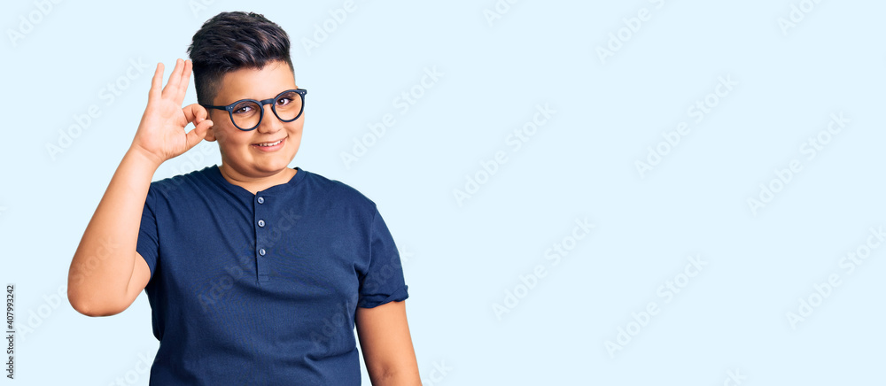 Fototapeta premium Little boy kid wearing casual clothes and glasses smiling positive doing ok sign with hand and fingers. successful expression.