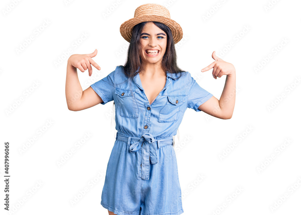 Brunette teenager girl wearing summer hat looking confident with smile on face, pointing oneself with fingers proud and happy. Brunette teenager girl wearing summer hat looking confident with smile on face, pointing oneself with fingers proud and happy.