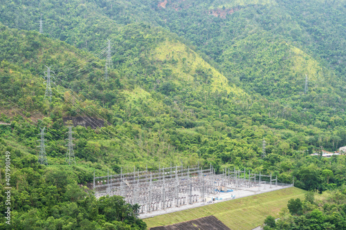 High voltage power distribution substation plant among mountain and forest in nature, Thailand.