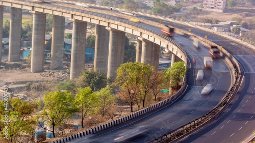 Time Lapse of Traffic on Curvy Highway Bridge over a River in Day Time with Big Pillars Visible  photo