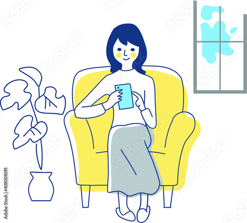 ソファーでスマートフォンをを操作する女性