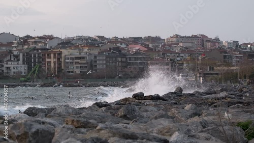 The waves crashing into the rocks in slow motion and flying seagulls in a stormy day at Istanbul Kadikoy Kalamis. There are two clip parts. photo