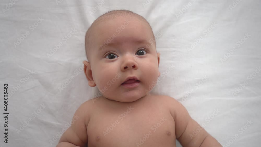 portrait of a newborn baby 5-7 months. Baby lies on the bed portrait of a newborn baby 5-7 months. Baby lies on the bed
