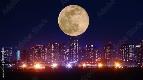 都市のイルミネーションと月の夜景