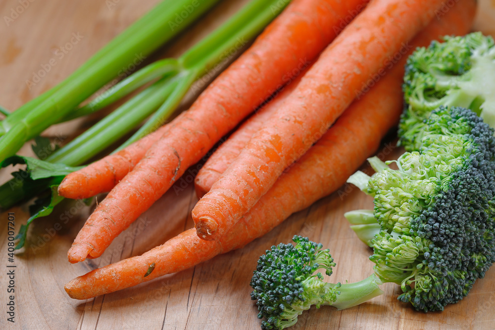 A close up photo of carrots, celery stalks, and some broccoli. A close up photo of carrots, celery stalks, and some broccoli.