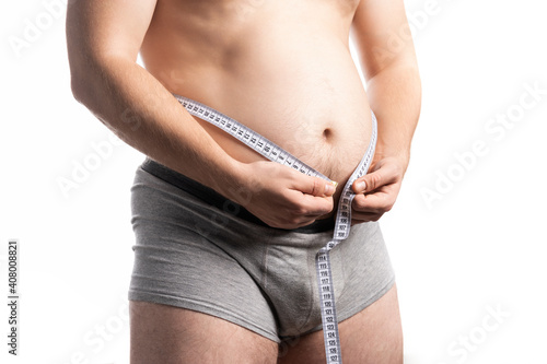 A man in the process of measuring his waist with a centimeter photo