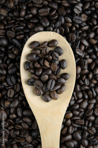 Wooden spoon with roasted coffee beans close-up