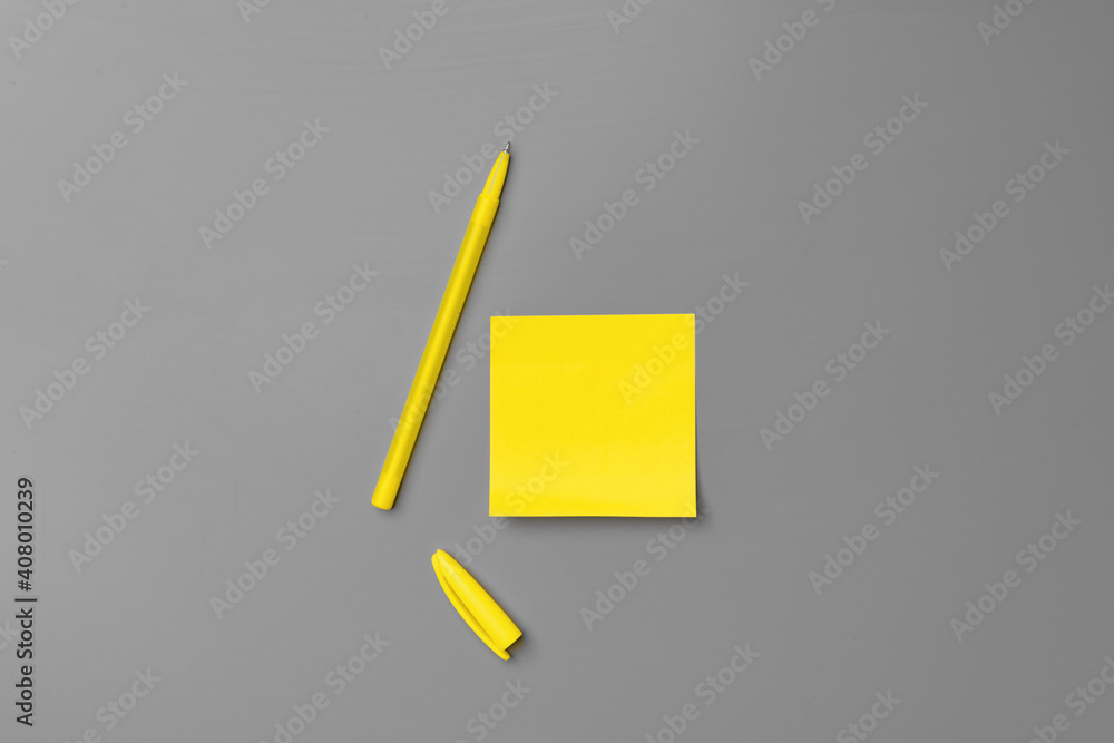 Yellow adhesive notes and pen on gray background Yellow adhesive notes and pen on gray background