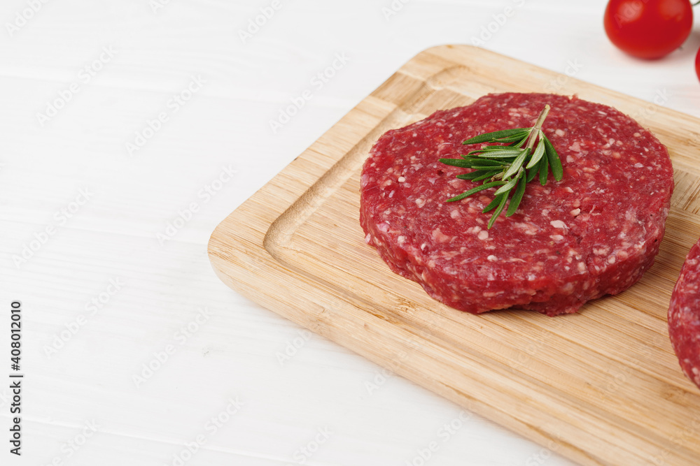 Two raw beef burger patties on wooden board Two raw beef burger patties on wooden board
