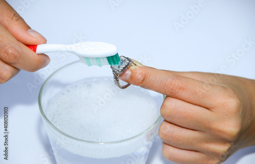 Clean jewelry with water and scrubbing brush.