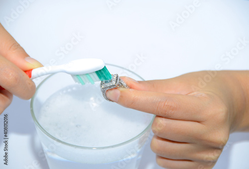 Clean jewelry with water and scrubbing brush.