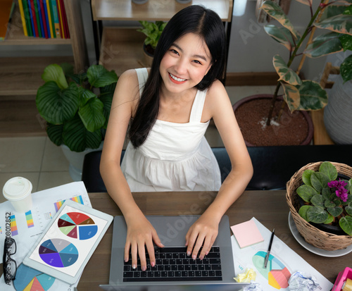 Asian girl typing data to her computer notebook for prepare her report