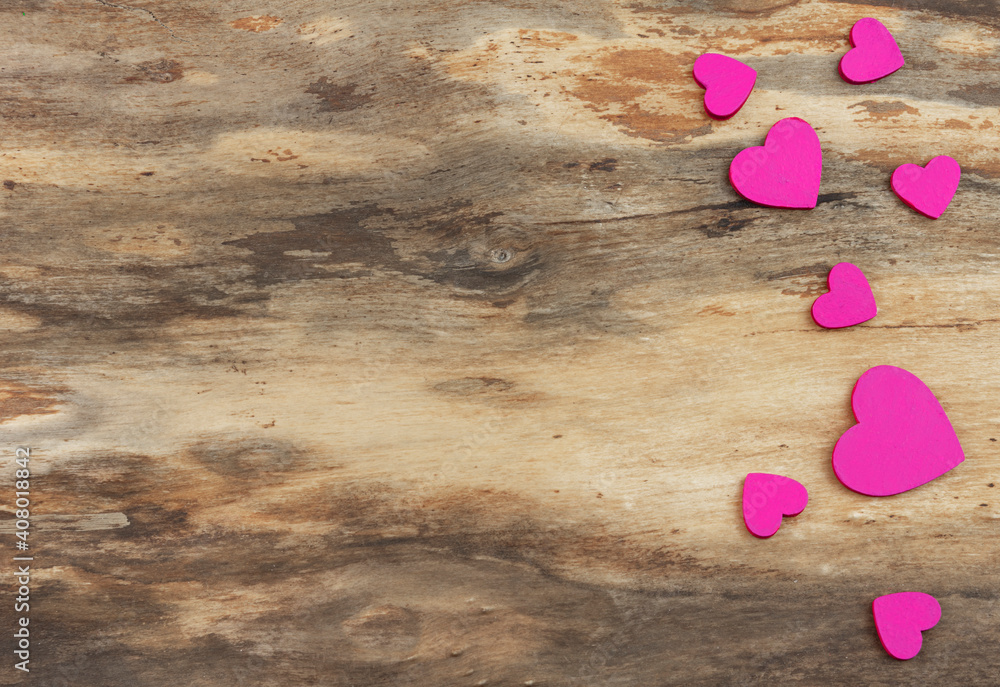 Fototapeta premium Eight pink hearts of different sizes on a natural wooden background. Background with copy space. Horizontal orientation. Valentine's day or wedding card