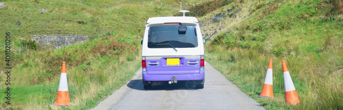 Purple campervan in remote mountain road trip