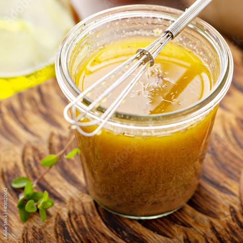 Homemade greek salad dressing or marinade in a glass jar photo