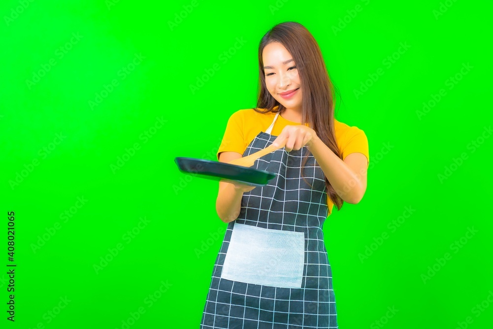 Portrait beautiful young asian woman wear apron with action on green background Portrait beautiful young asian woman wear apron with action on green background