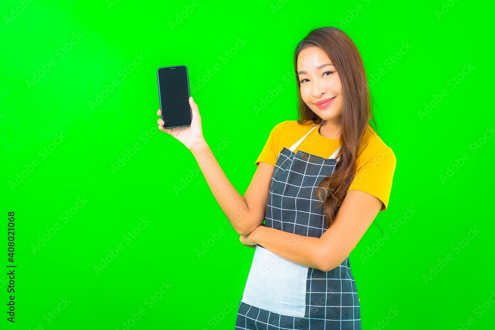 Portrait beautiful young asian woman wear apron with action on green background Portrait beautiful young asian woman wear apron with action on green background