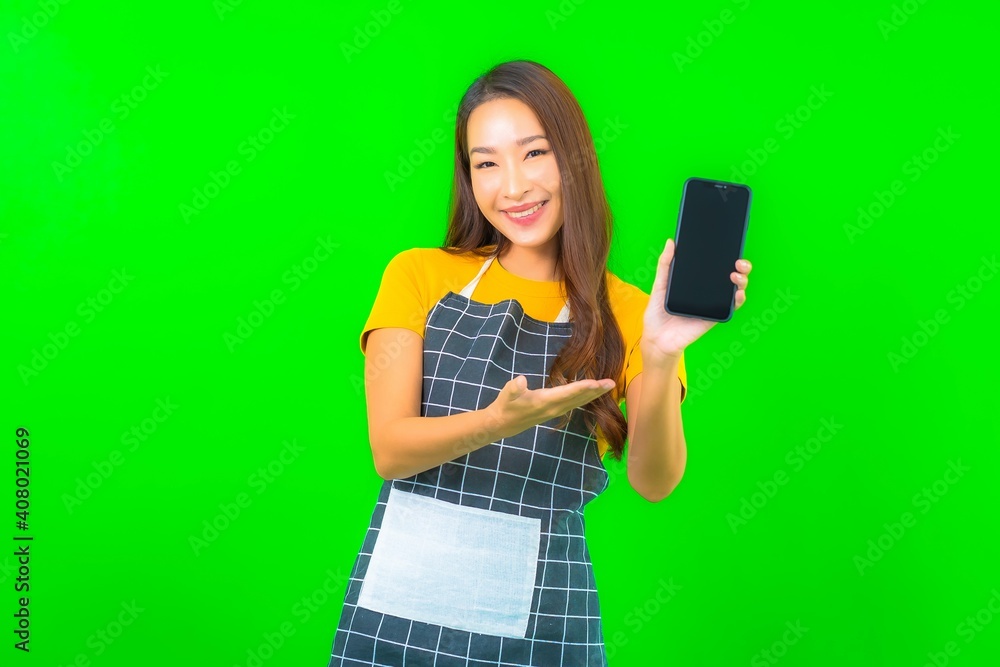 Portrait beautiful young asian woman wear apron with action on green background Portrait beautiful young asian woman wear apron with action on green background