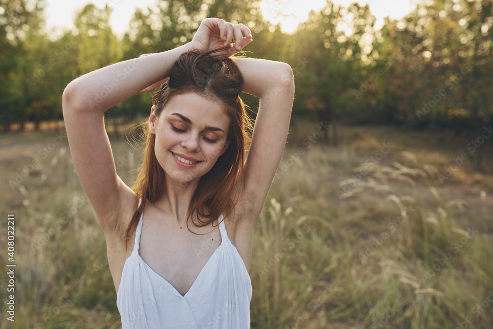 happily traveler resting in a field in nature and trees in the background gesturing with her hands happily traveler resting in a field in nature and trees in the background gesturing with her hands