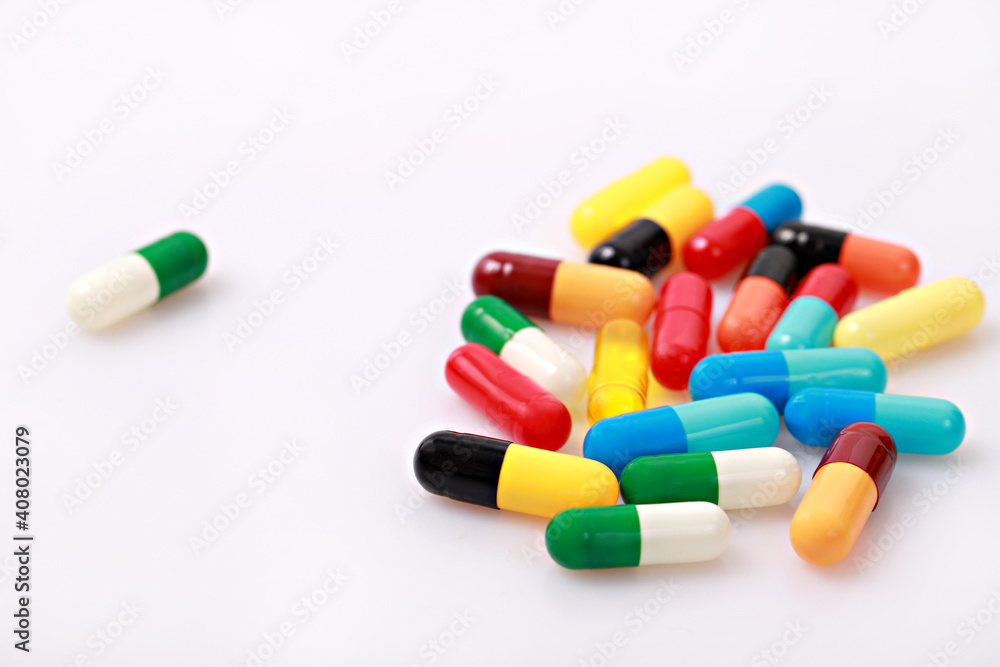 Variety medicine capsule pills on white background.