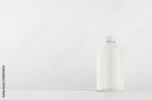 Transparent plastic low thick bottle with water or cosmetic product with silver cap mockup on white background, template, copy space.