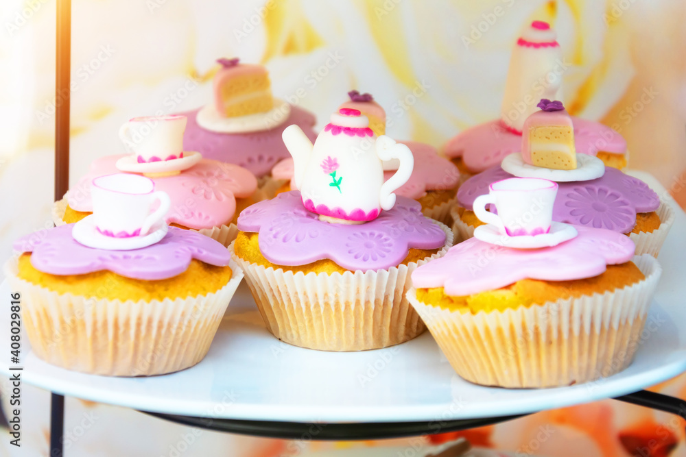 Cakes, cupcakes with teapot-shaped icing and tea cups. Cakes, cupcakes with teapot-shaped icing and tea cups.