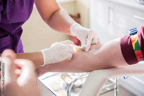 Nurse taking a patient's blood sample at lab