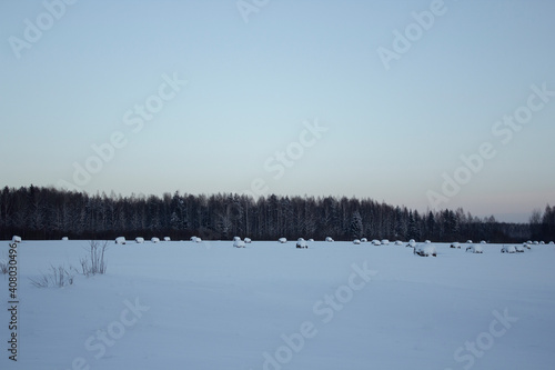 Haystacks on the field in winter. A snow-covered field with haystacks. Snow fields. © Ксения Ульянова